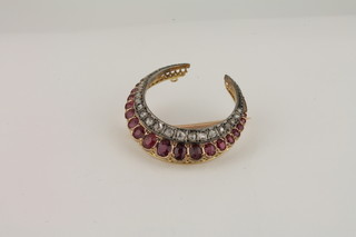 A Victorian crescent shaped brooch set rubies and diamonds
