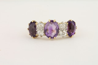 An 18ct yellow gold dress ring set 3 oval cut amethysts and 4 diamonds