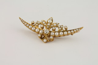 A 15ct gold brooch set a diamond to the centre surrounded by demi-pearls, approx .30ct  ILLUSTRATED