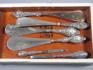 4 silver handled shoe horns, a pair of silver handled tweezers  and a do. nail file