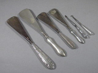 4 silver handled shoe horns, a silver handled button hook and a silver handled manicure implement