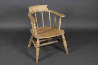 A bleached elm Captain's chair raised on turned supports