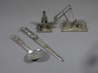 A white metal model of a figure sitting by an open fire, do.  Dutch bridge and a paper knife