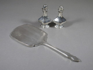 A silver salt and pepper of waisted form and a silver backed hand mirror