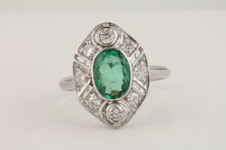 An 18ct white gold dress ring an oval cut emerald surrounded by  diamonds 1/0.50ct
