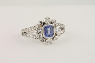 An 18ct white gold dress ring set a rectangular cut sapphire  supported by diamonds