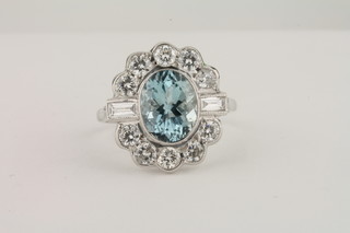 An 18ct white gold dress ring set an oval cut aquamarine  surrounded by diamonds