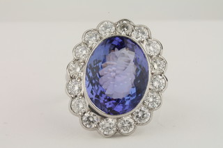 An 18ct white gold dress ring set a large oval cut tanzanite surrounded by diamonds, approx 7.50/1.50ct