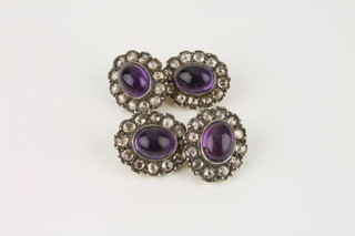 A pair of gold cufflinks set cabouchon cut amethysts surrounded  by diamonds