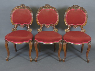 A set of 3 Victorian carved walnut show frame armchairs of  serpentine outline, raised on cabriole supports, by Eadon & Sons  of Sheffield