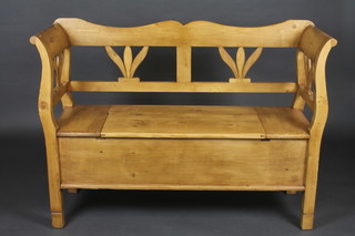 A Continental stripped and polished pine settle, the seat with hinged lid 49"