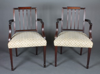 A pair of Georgian style mahogany stick and rail back carver  chairs, raised on square tapering supports with spade feet