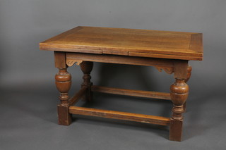 An oak refectory style drawleaf dining table, raised on bulbous turned supports with box framed stretcher 49"