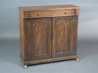 A Regency mahogany chiffonier fitted a drawer above a cupboard enclosed by a panelled door, raised on brass ring supports 36"