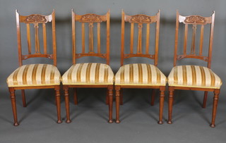 A set of 4 Edwardian carved walnut stick and rail back dining  chairs with upholstered drop in seats on cabriole supports