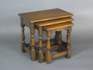 An oak nest of 3 rectangular interfitting coffee tables, raised on turned and block supports, 23"