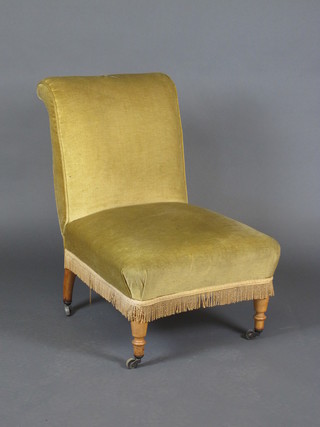 A nursing chair upholstered in yellow material, raised on turned  supports