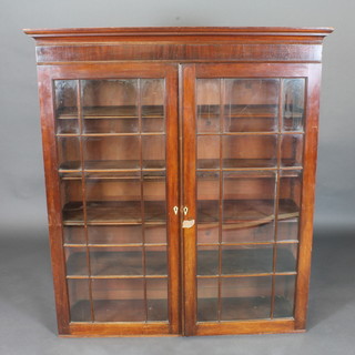 A 19th Century mahogany bookcase top with moulded cornice,  the shelved interior enclosed by glazed panelled doors 48"