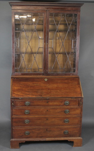 A Georgian mahogany bureau bookcase with moulded and dentil cornice, the fall front revealing a well fitted interior above 4 long  drawers with brass drop handles, raised on bracket feet 42"   ILLUSTRATED
