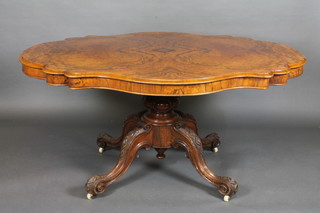 A Victorian shaped figured walnut Loo table, raised on a tripod  base 60"  ILLUSTRATED