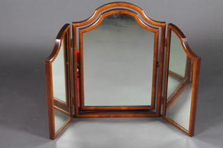 An arch shaped triple plate dressing table mirror contained in a walnut frame