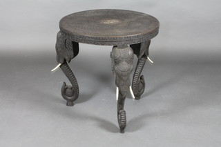 An Indian ebonised circular carved table with ivory tusks 25"