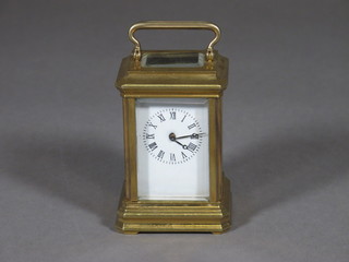 A reproduction carriage clock with enamelled dial and Roman numerals, contained in a brass case 2"