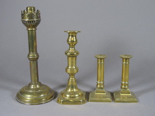 A pair of 19th Century brass candlesticks raised on square bases 5 1/2", a 19th Century candlestick 8" and a sprung loaded  candlestick