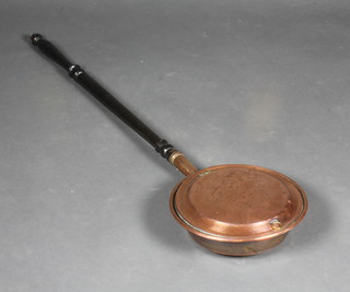 A copper warming pan with a turned ebony handle and a pair of carved oak bellows