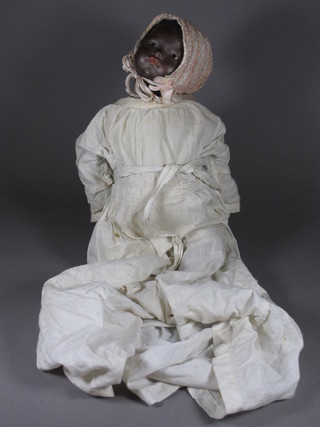 An Armand Marseille black porcelain headed doll with open and shutting eyes, the head incised AM Germany, damage to fingers,   ILLUSTRATED