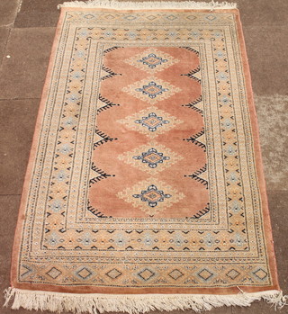 A Pakistan hand knotted pink ground rug with 5 stylised octagons  to the centre 61" x 37"