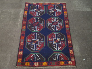 A Persian Balochi blue ground and patterned rug with 6 octagons  to the centre 56" x 32"