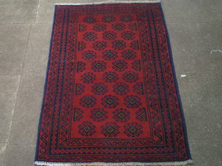 A Persian Balochi red ground rug with numerous stylised  octagons to the centre within multi row border 53" x 34"