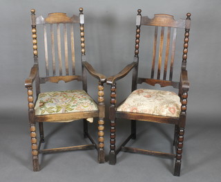 A pair of oak stick and ladder back carver chairs with upholstered drop in seats, raised on spiral turned supports