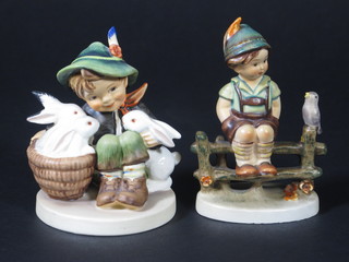 2 Hummel figures - seated boy with basket of rabbits 4" and seated boy on fence with bird, f and r,