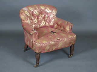 A tub back armchair upholstered in pink material raised on turned  supports