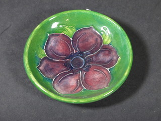 A circular Moorcroft dish with floral decoration, base with paper  label and marked Potter to the Queen, 3"