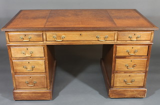An Edwardian mahogany kneehole pedestal desk with inset tooled writing surface above 1 long and 8 short drawers 54"