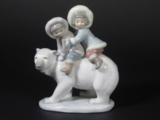 A Lladro figure of a 2 children riding a polar bear 6 1/2"
