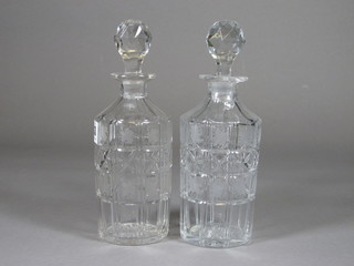 A pair of cylindrical panel cut decanters and stoppers 9"