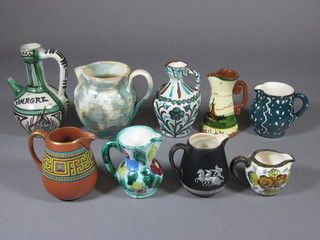 A Torquay Mottoware waisted jug 4" and a collection of 8 other jugs