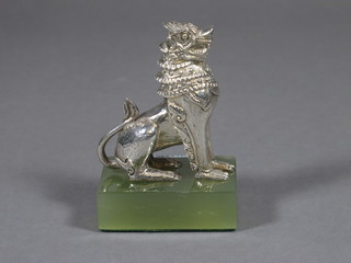 A white metal model of a seated Eastern mythical beast raised on  a green marble base 3"