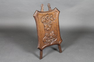 A carved oak Art Nouveau fire screen of shield shape 17"