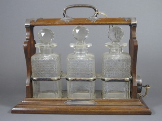 An oak and and silver plated 3 bottle tantalus complete with 3 cut glass decanters by Walker & Hall - The Only Hold Fast   ILLUSTRATED