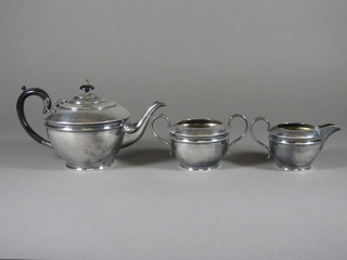 A circular Britannia metal 3 piece tea service with teapot, twin  handled sugar bowl and milk jug
