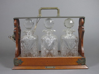 An oak and silver plated tantalus fitted 4 cut glass bottles by Elkington & Co  ILLUSTRATED