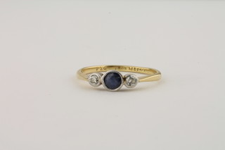 A lady's 18ct gold dress ring set a circular cut sapphire supported  by 2 diamonds