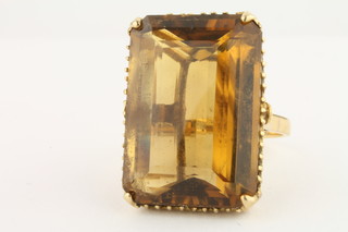 A yellow gold ring set a rectangular amber cut stone