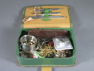 A green leather box containing a small collection of costume jewellery
