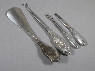 A silver handled button hook, do. shoe horn and 2 silver handled implements